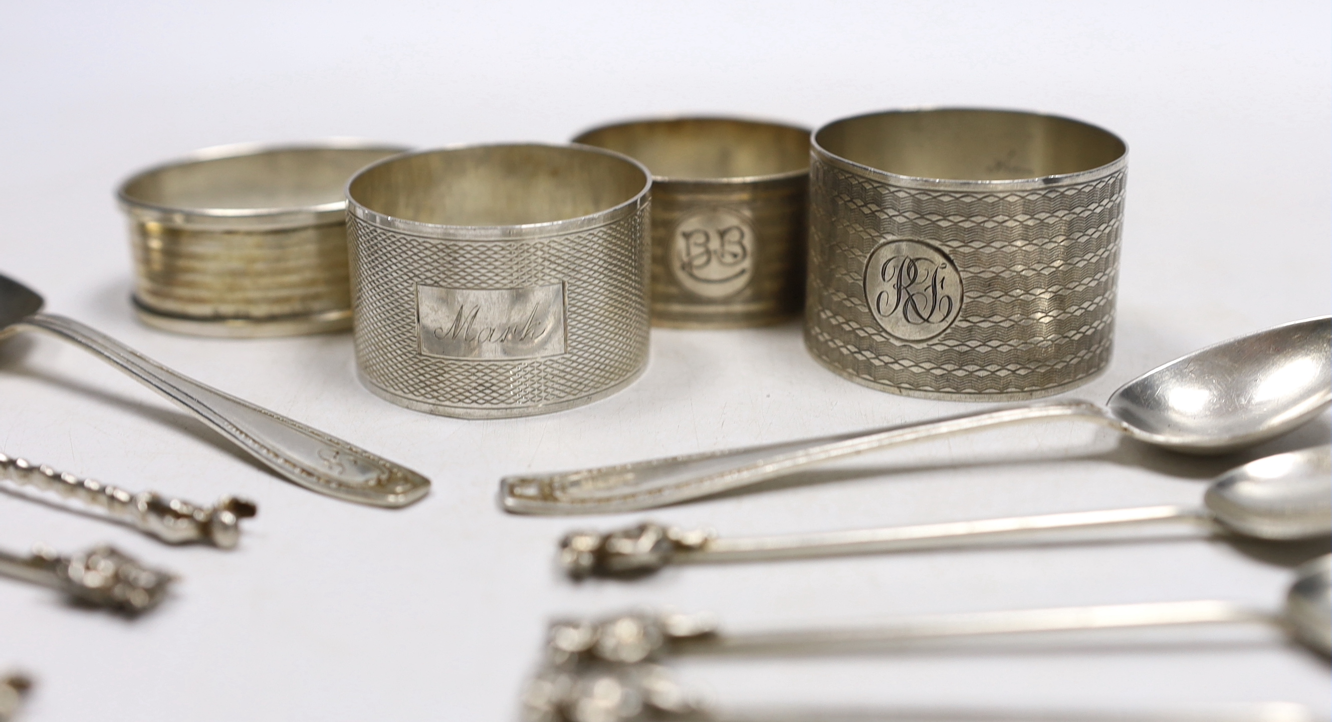 Four assorted silver napkin rings, six assorted silver coffee spoons including four with 'imp' terminals and four continental white metal coffee spoons.